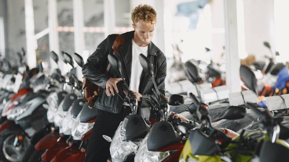 Un hombre mirando motocicletas en un concesionario.
